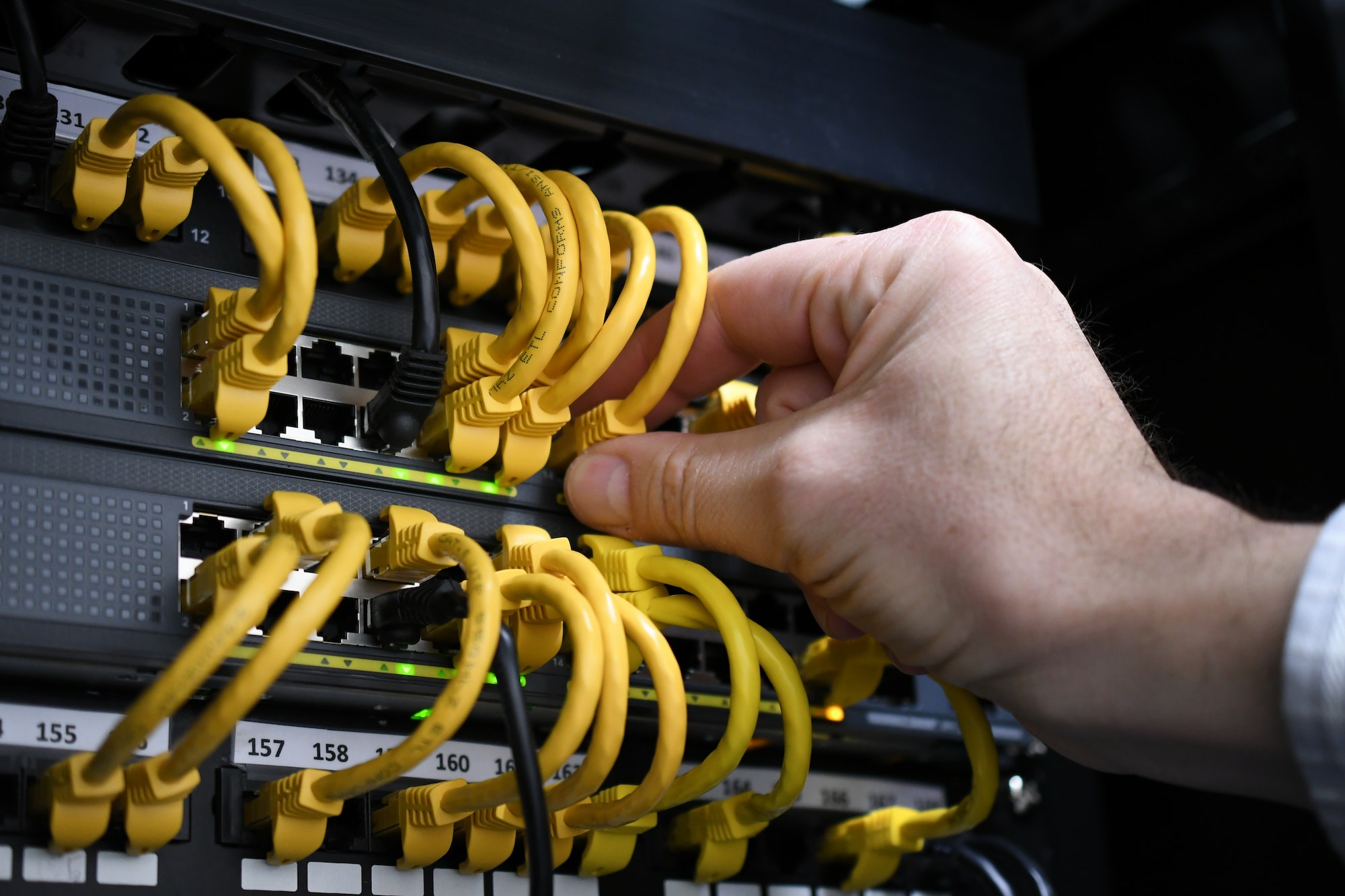 IT Department - cables wires connections to servers - IT guy making adjustments