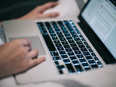 Using laptop MacBook working typing social media at home mobile technology digital work keyboard