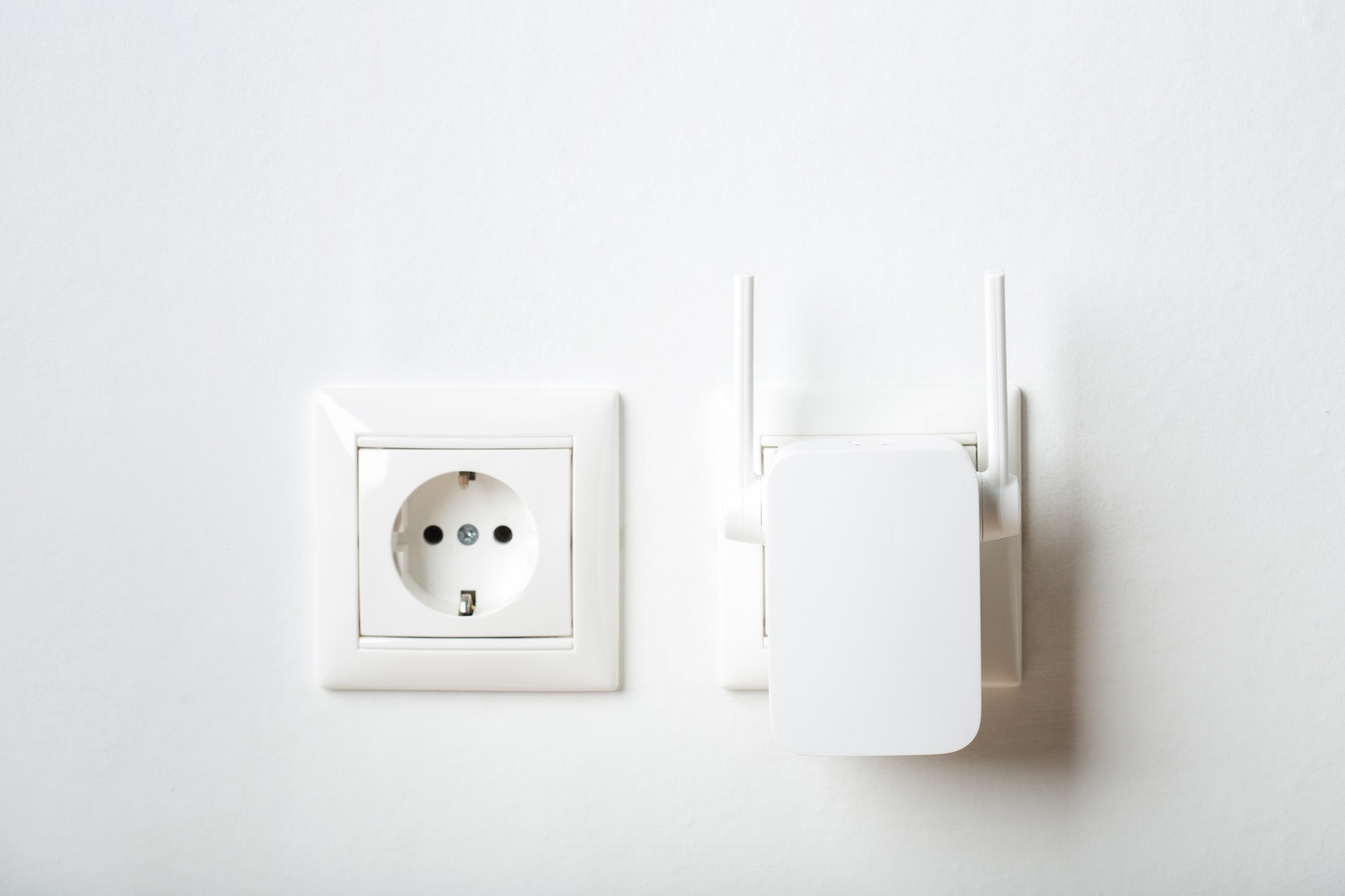 white wi-fi repeater indoors at home in outlet. wireless router.