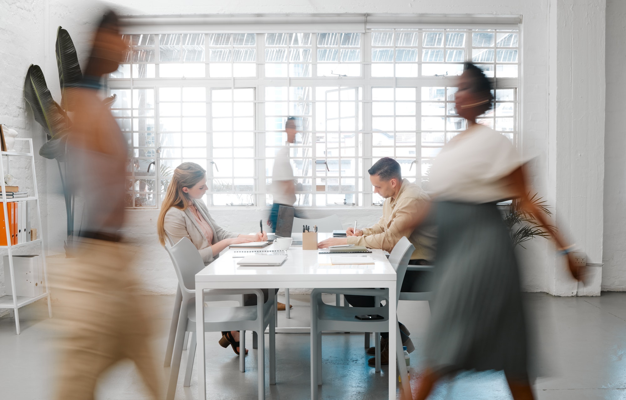 Blurred designers, marketing or freelance professionals working together in a modern office. Busine