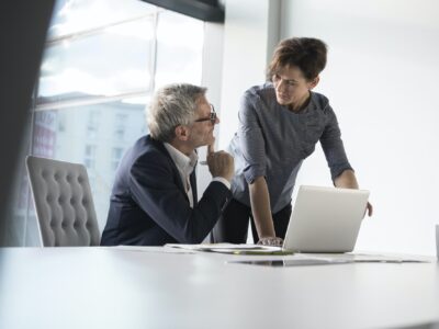 Businessman and businesswoman with laptop in office