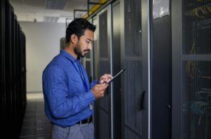 Man, tablet and technician in data center, research and programming. Information technology, readin